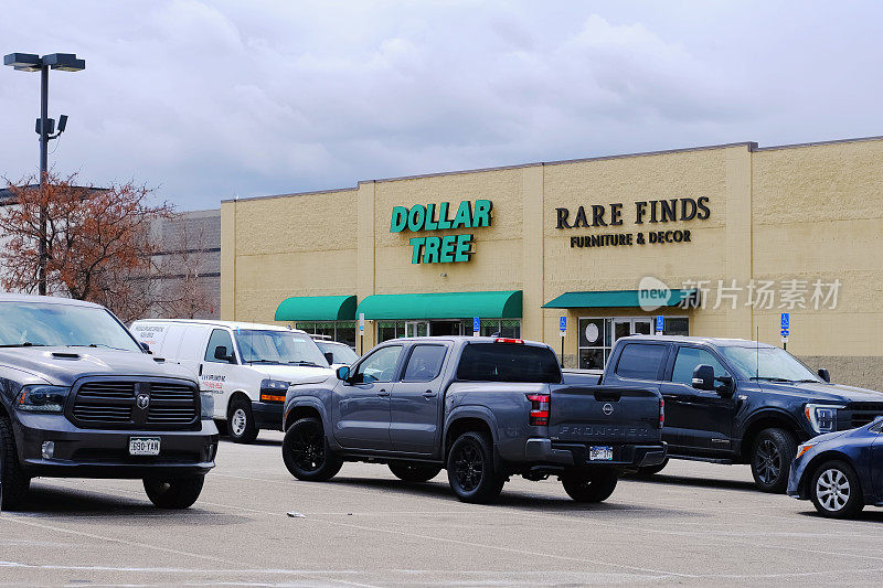 Dollar Tree零售商店前门有公司品牌标志和停车场停放的汽车。